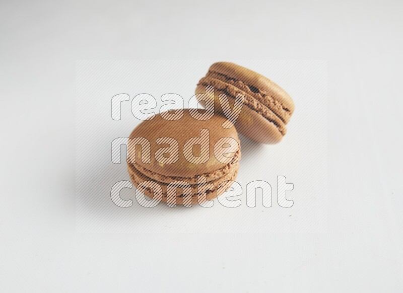 45º Shot of two Brown Coffee macarons on white background