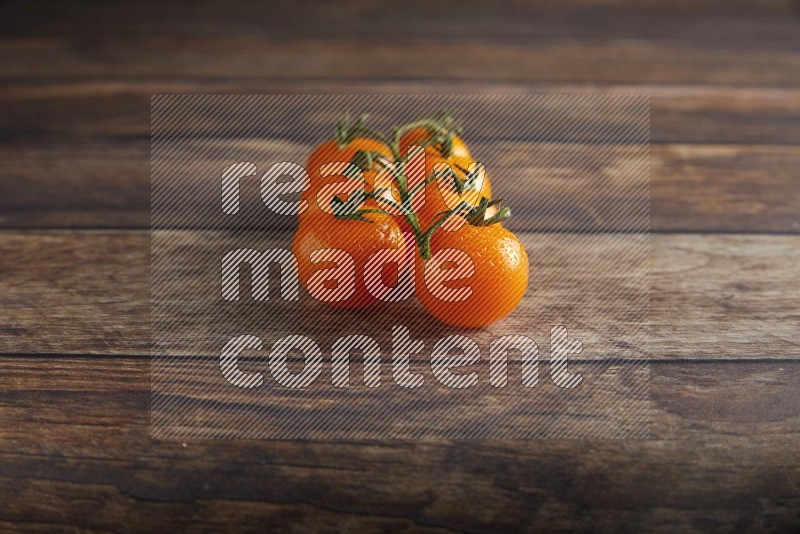 Orange cherry tomato vein on a textured wooden background 45 degree