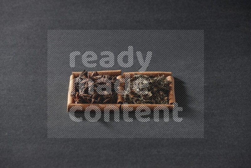 2 squares of cinnamon sticks full of star anise and dried basil on black flooring