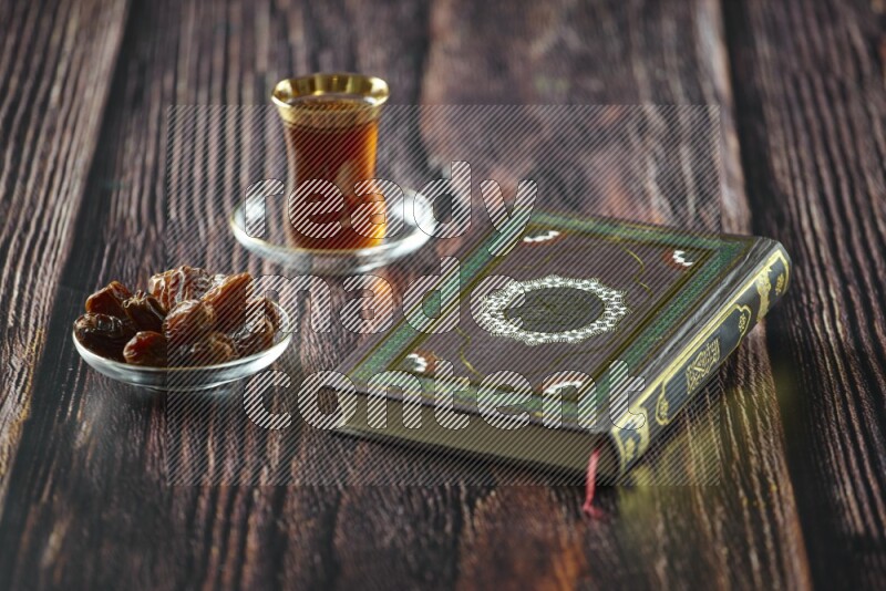 Quran with dates, prayer beads and different drinks all placed on wooden background