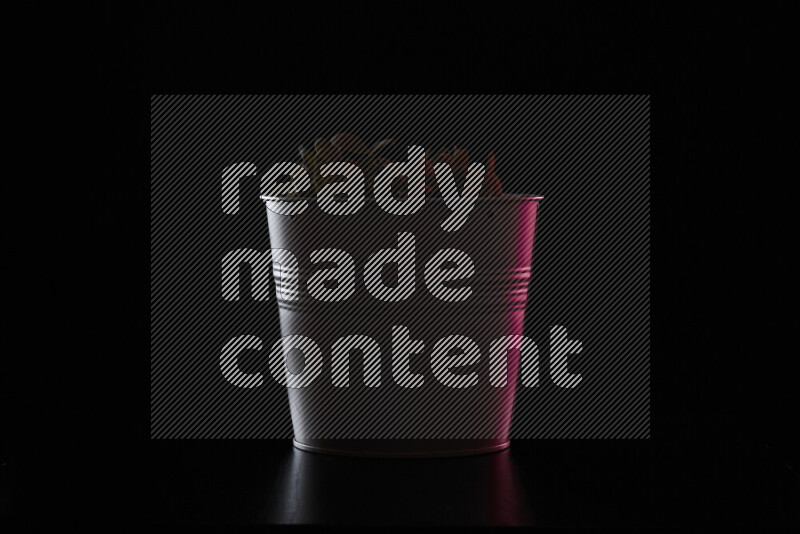 A plant pot with colored rim light against black background