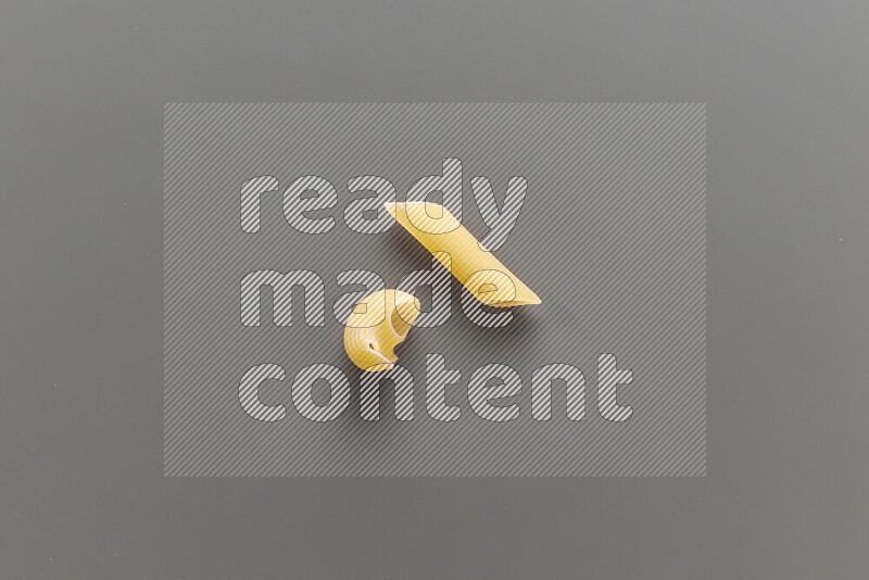 Pipe pasta with other types of pasta on grey background