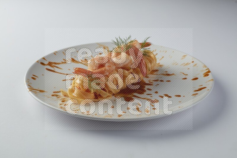 Fettuccini red sauce pasta with shrimp in a white plate on a white background