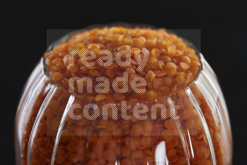 Lentils in a glass jar on black background