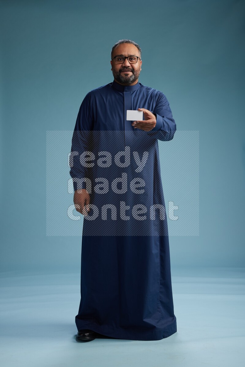 Saudi Man without shimag Standing holding ATM on blue background