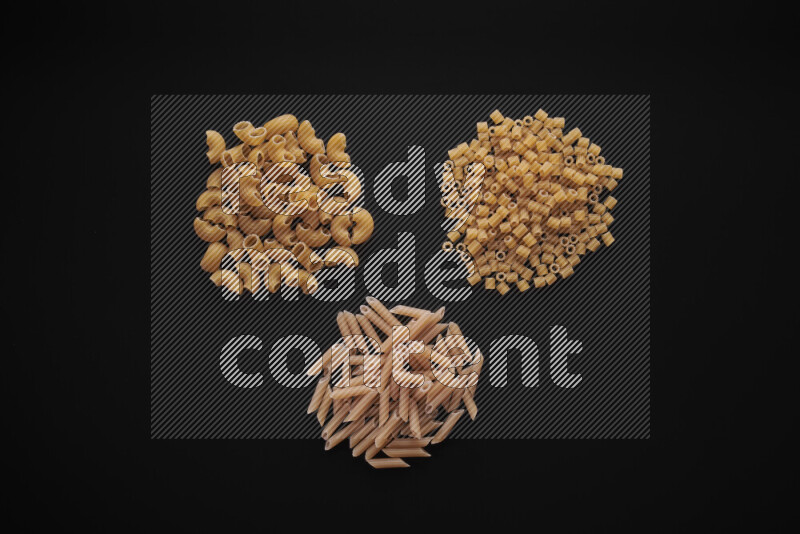 Different pasta types in bunches on black background