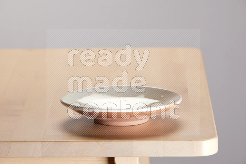 multi-colored pottery Plate on a wooden table edge