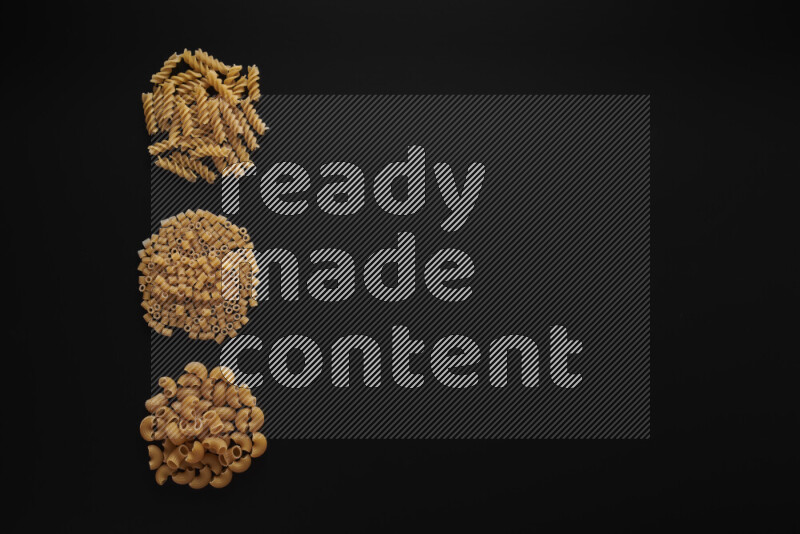 Different pasta types in 3 bunches on black background