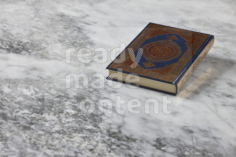 Quran with a prayer beads on grey marble background
