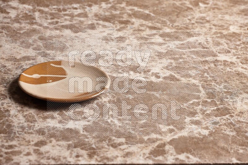 صحن فخاري متعدد الألوان على خلفية من الرخام البيج