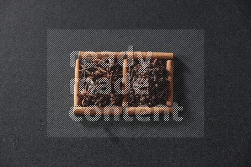 2 squares of cinnamon sticks full of star anise and cloves on black flooring