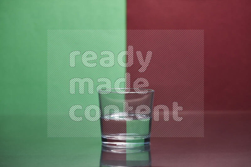 The image features a clear glassware filled with water, set against green and dark red background