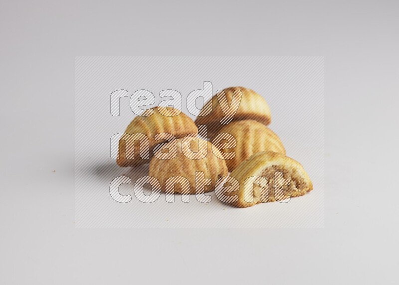 Five Pieces of Maamoul filled with walnut paste  one of them is cut with direct on white background