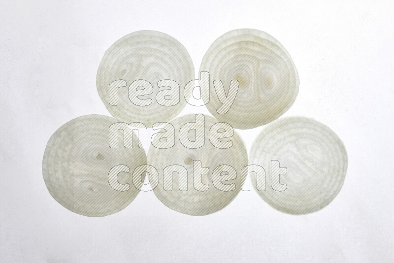 Onion slices on illuminated white background