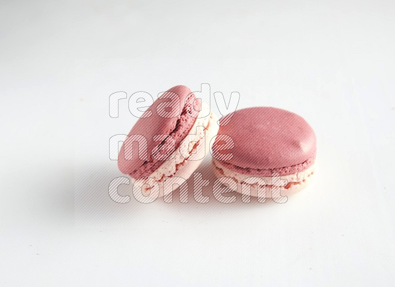 45º Shot of two Pink Litchi Raspberry macarons on white background