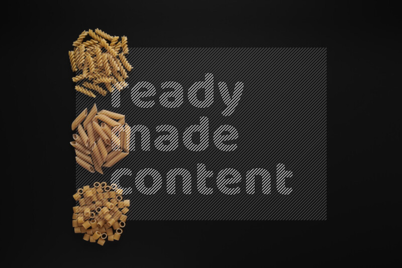Different pasta types in 3 bunches on black background