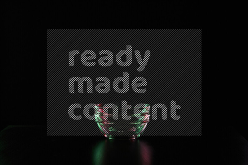 Glassware with rim light in red and green against black background