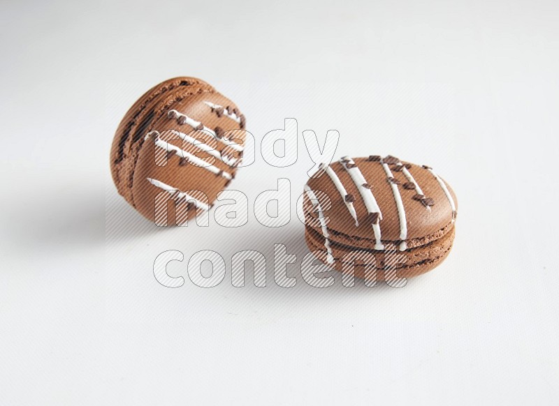 45º Shot of two Brown white Chocolate Caramel macarons on white background