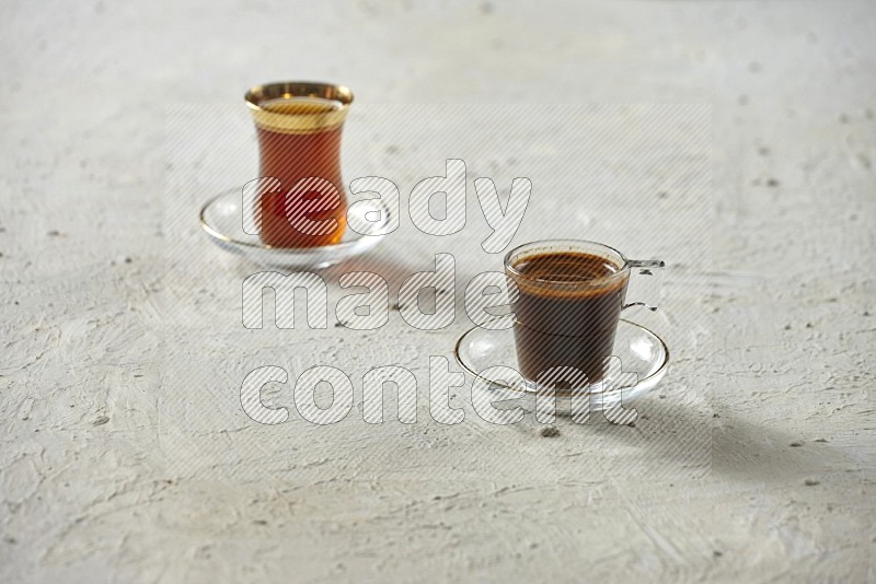 كوب زجاجي من القهوة مع التمر والشاي على خلفية بيضاء