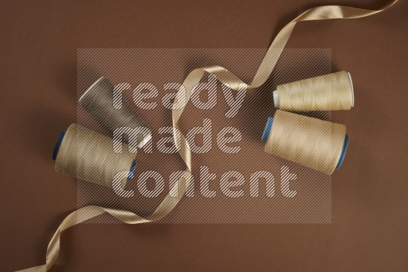 A brown collection of sewing and tailoring tools arranged on a brown background