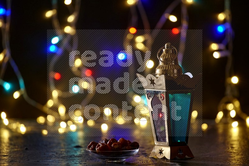 A traditional ramadan lantern surrounded by glowing fairy lights in a dark setup