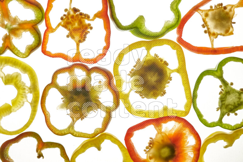 Mixed vegetables and fruits slices on illuminated white background