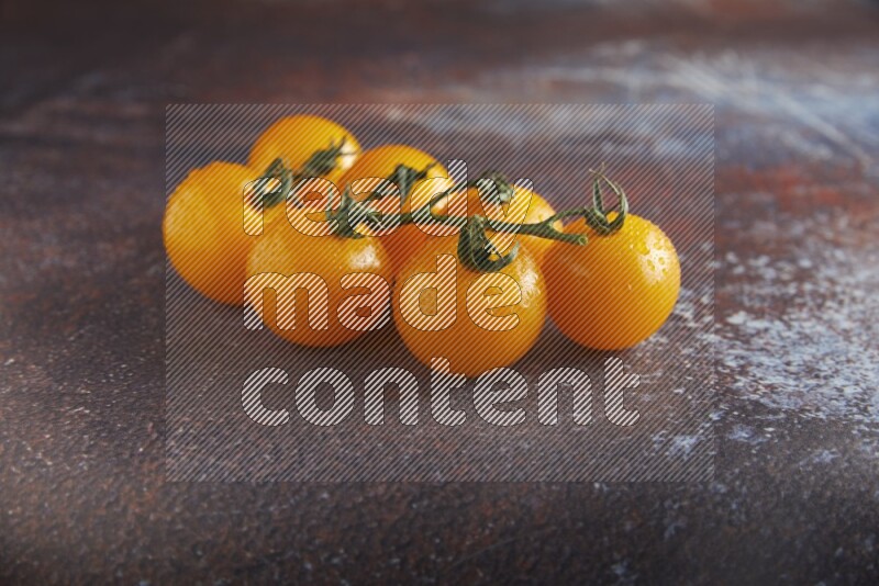 Yellow cherry tomato vein on reddish rustic metal background 45 degree