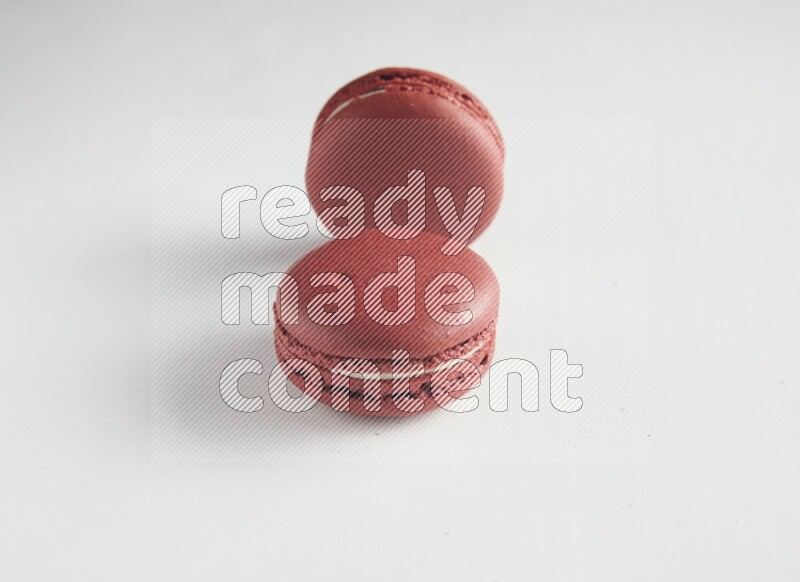 45º Shot of two Red Velvet macarons on white background
