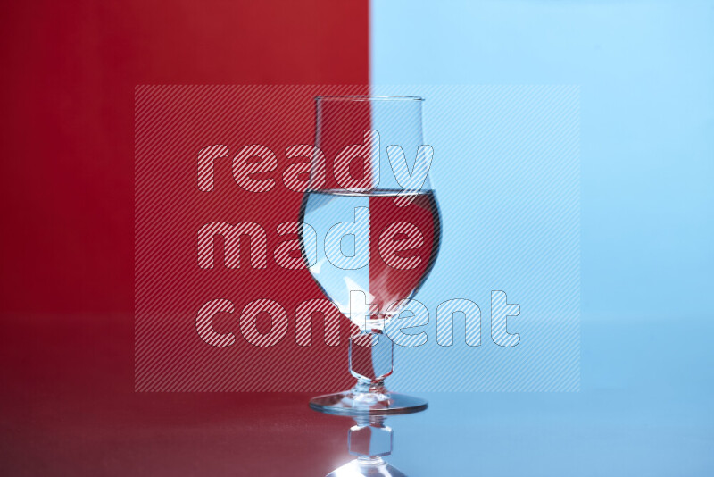 The image features a clear glassware filled with water, set against red and light blue background