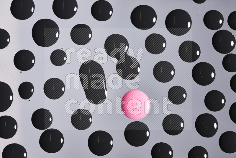 Close-ups of abstract pink and black paint droplets on the surface
