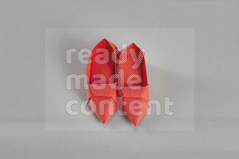 Origami shoes on grey background