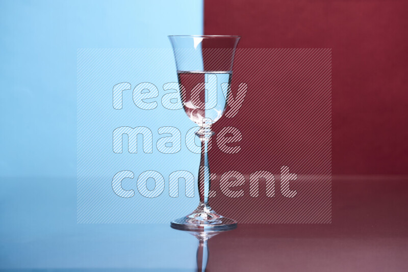 The image features a clear glassware filled with water, set against light blue and dark red background