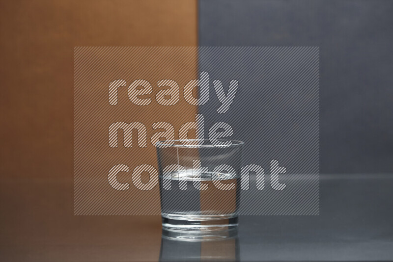 The image features a clear glassware filled with water, set against brown and dark blue background