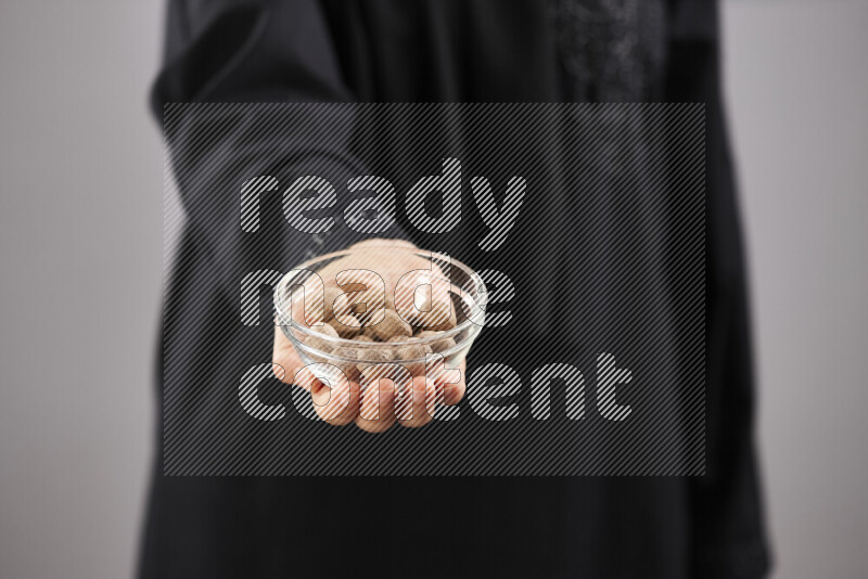 Woman in abaya holding different kinds of spices in different positions