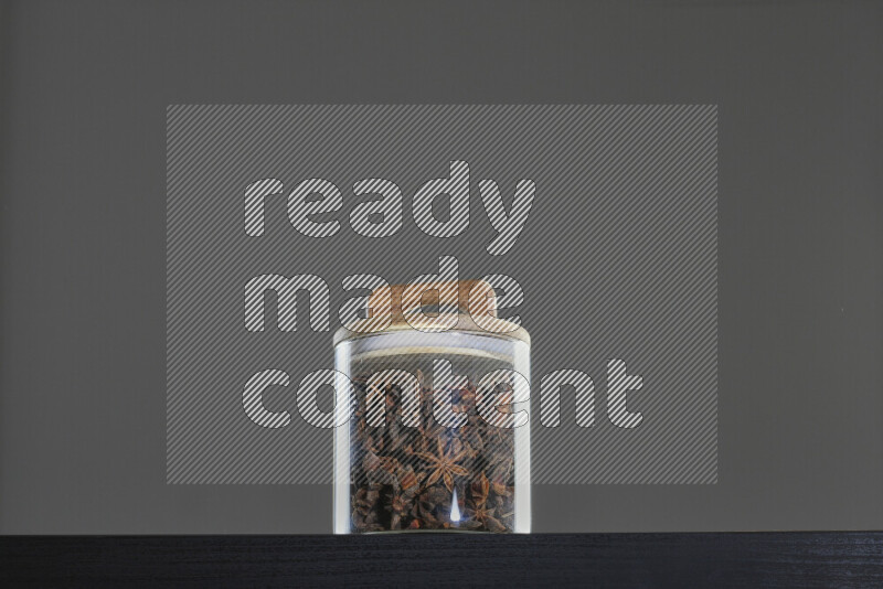 Star anise in a glass jar on black background