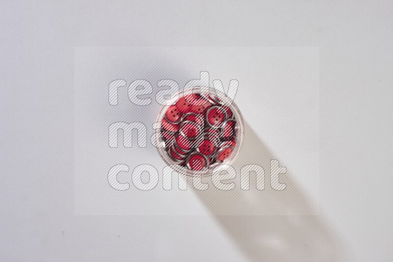 Colored buttons in a glass jar on grey background