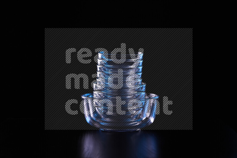 Glassware with rim light in blue and white against black background