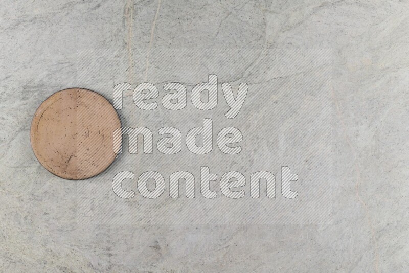 A pottery coaster on grey marble background