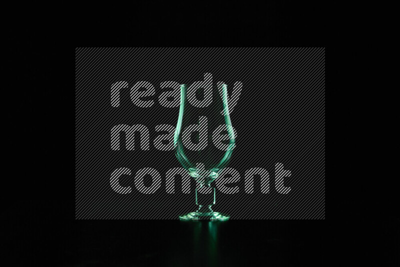 Glassware with rim light in green against black background