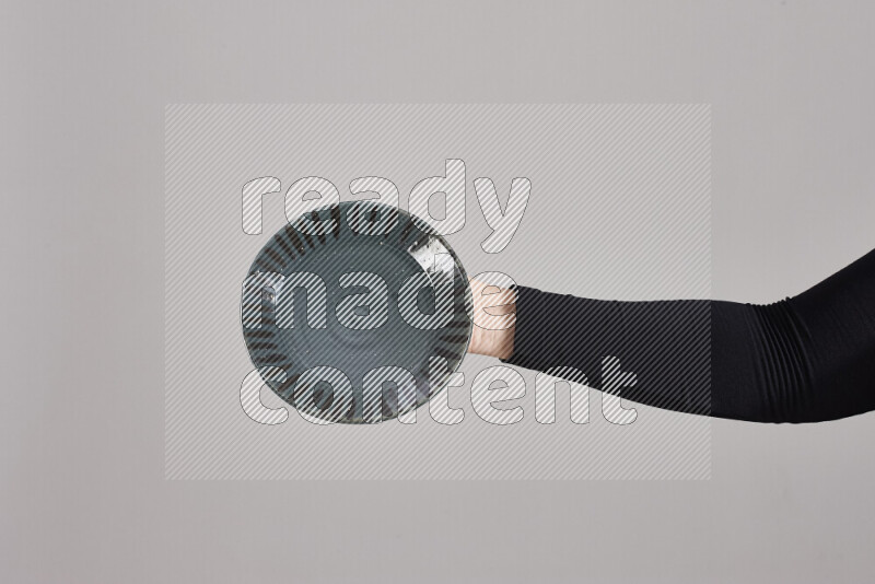 امرأة ترتدي عباءة سوداء تحمل أدوات فخارية مختلفة في أوضاع متعددة