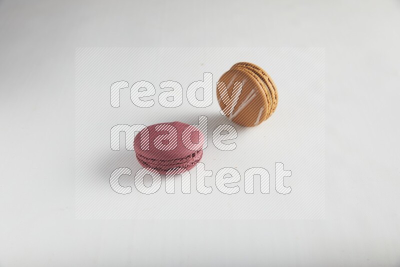 45º Shot of of two assorted Brown Irish Cream, and Red Cherry macarons on white background