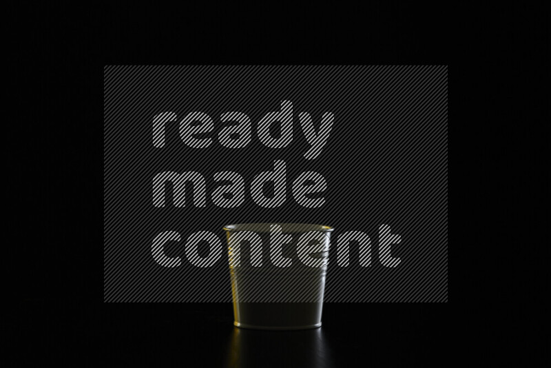 A plant pot with colored rim light against black background