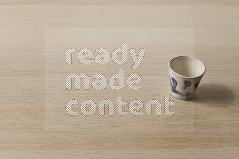 A pottery cup on light wooden background