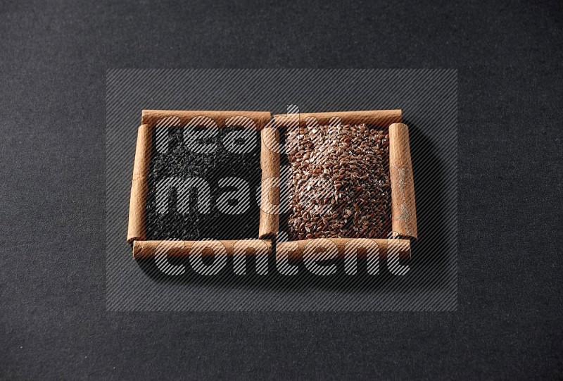 2 squares of cinnamon sticks full of flaxseeds and black seeds on black flooring