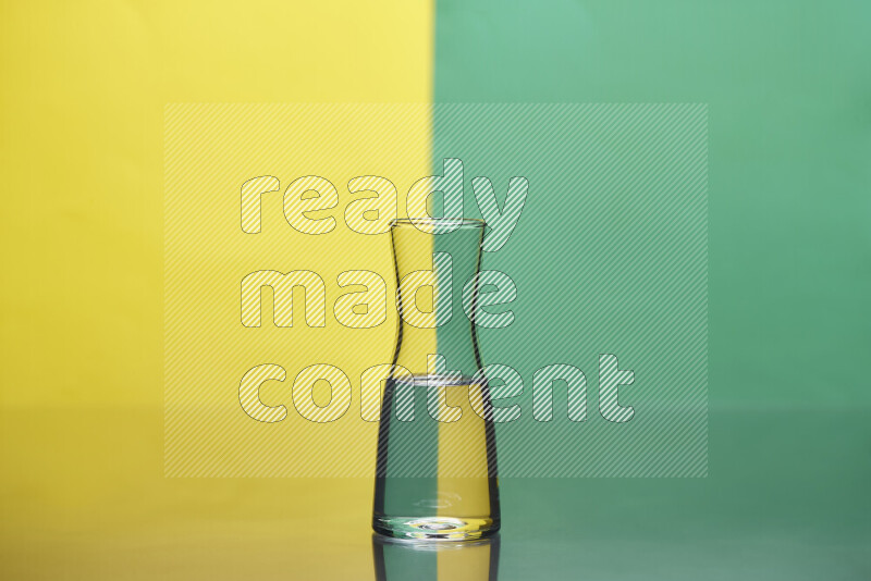 The image features a clear glassware filled with water, set against yellow and green background