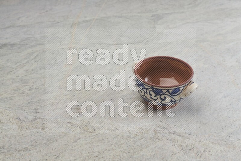 A multicolored pottery bowl on grey marble background