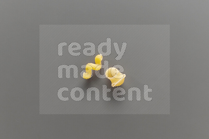 Twist pasta with other types of pasta on grey background