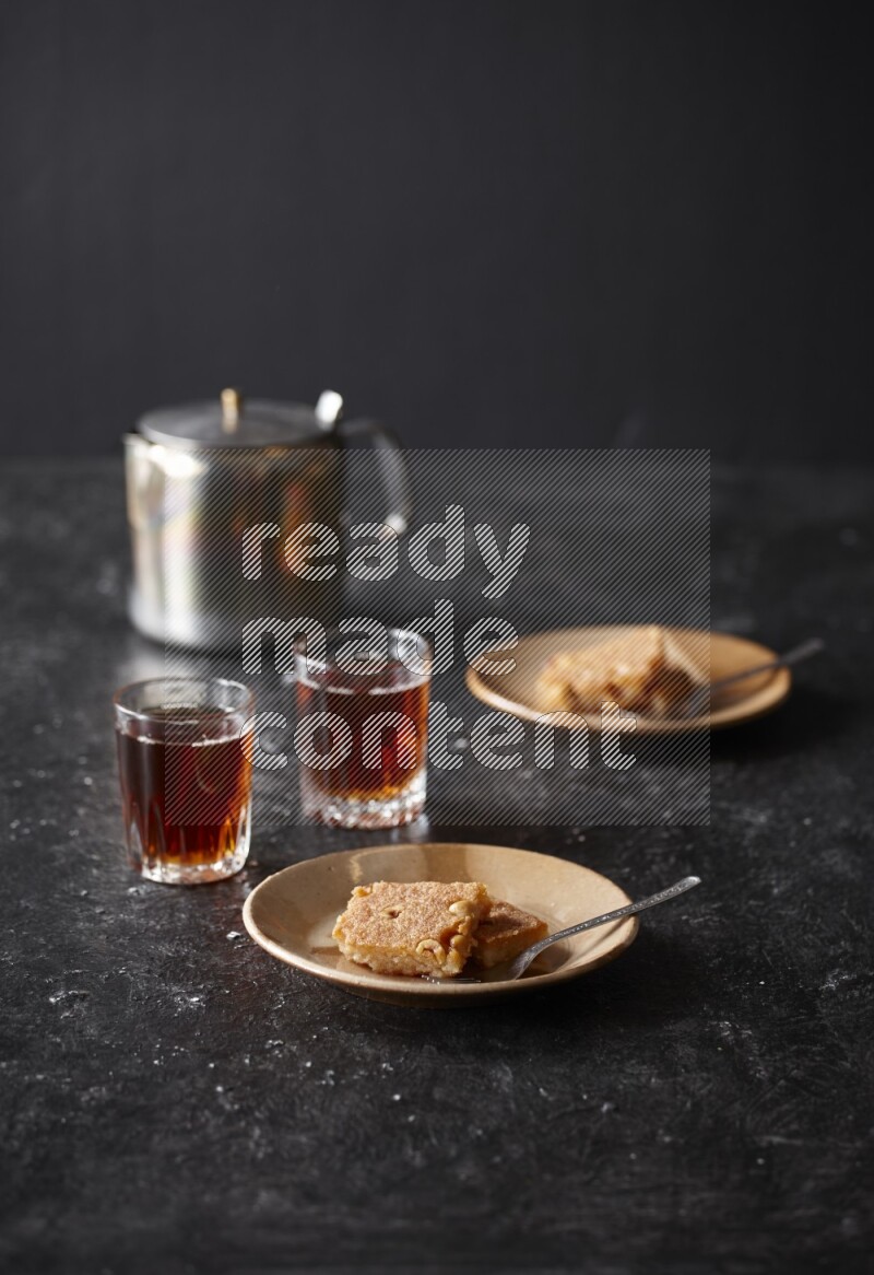 Basbousa with tea in a dark setup