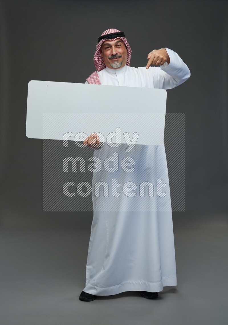 Saudi man with shomag Standing holding social media sing on gray background