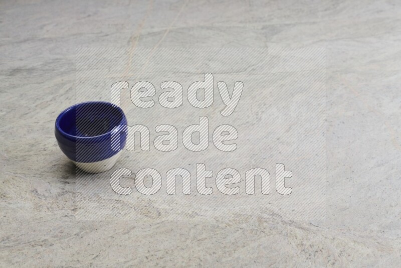 A multicolored pottery bowl on grey marble background